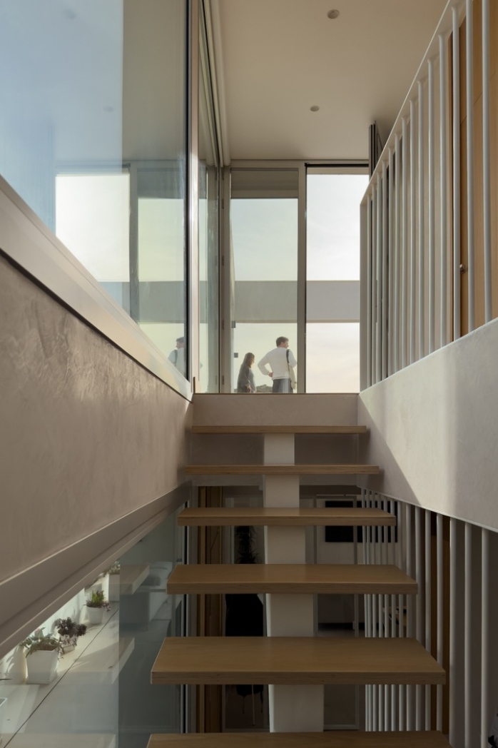 Detalle de escalera exterior con barandilla de cristal y luz natural